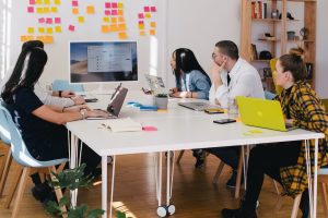A team looking at a computer learning about the capacity utilization formula.