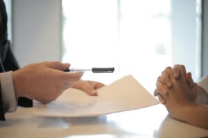 Close-up of a contract signing with hands over documents. Professional business interaction.